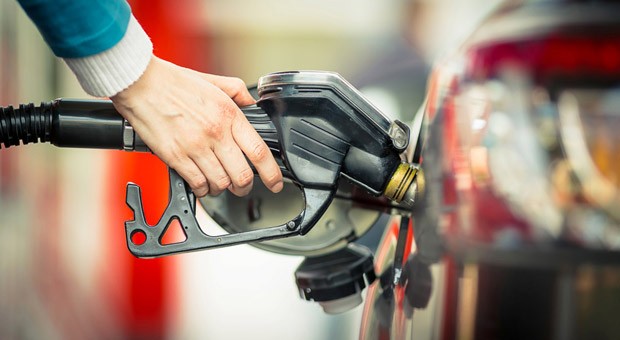 Eine Nahaufnahme davon, wie eine Hand ein Auto betankt.