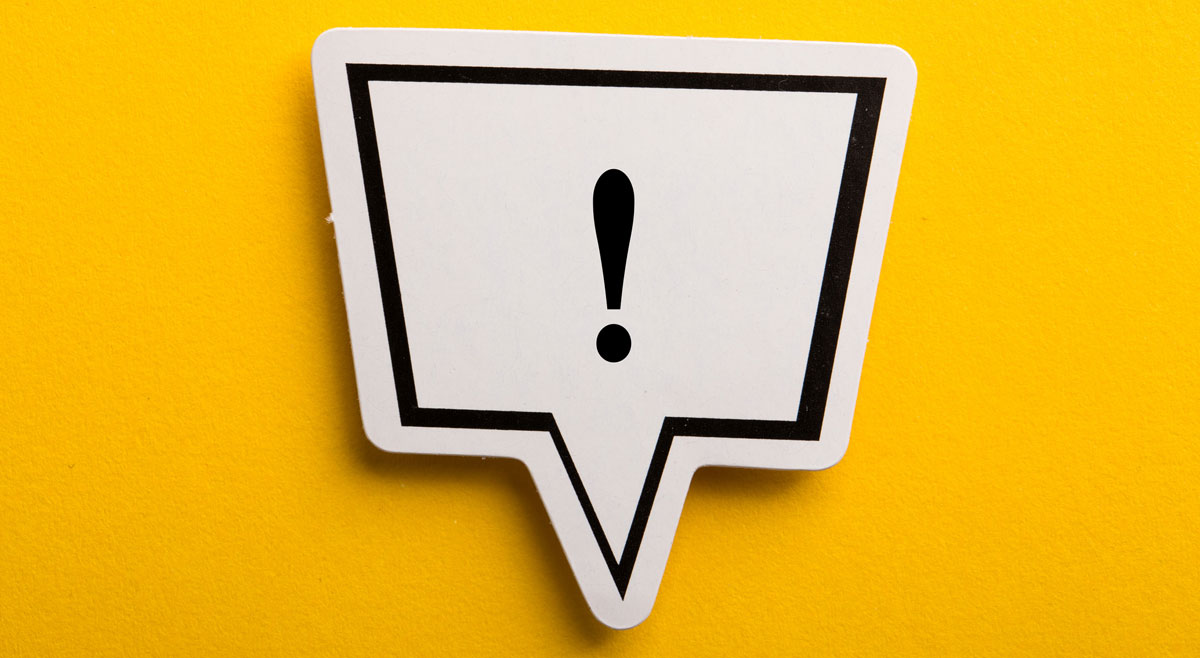 Eine Sprechblase mit einem Ausrufezeichen auf gelbem Hintergrund.