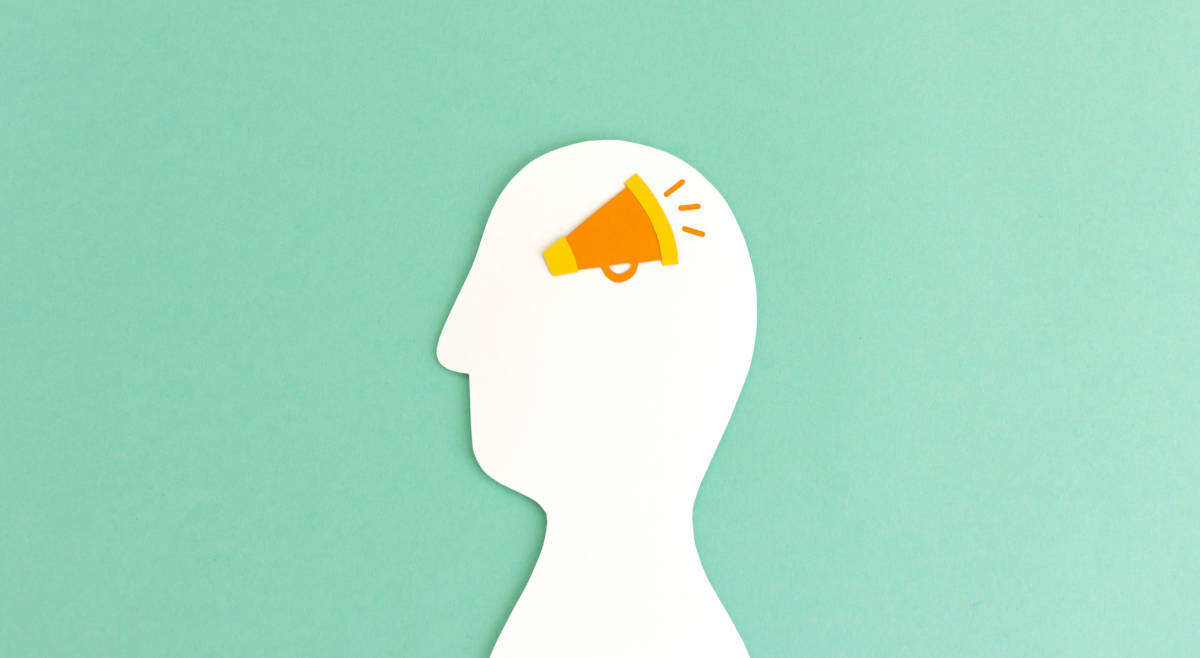 Eine einfach stilisierter weißer Papier-Kopf, in dem ein Megafon tönt.