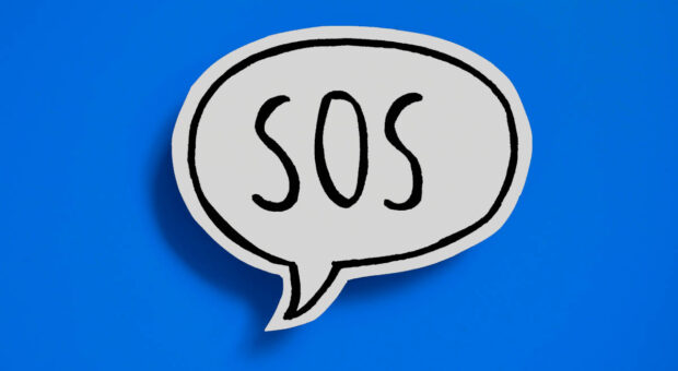 Eine weiße Sprechblase mit schwarzem SOS als Text auf blauem Hintergrund