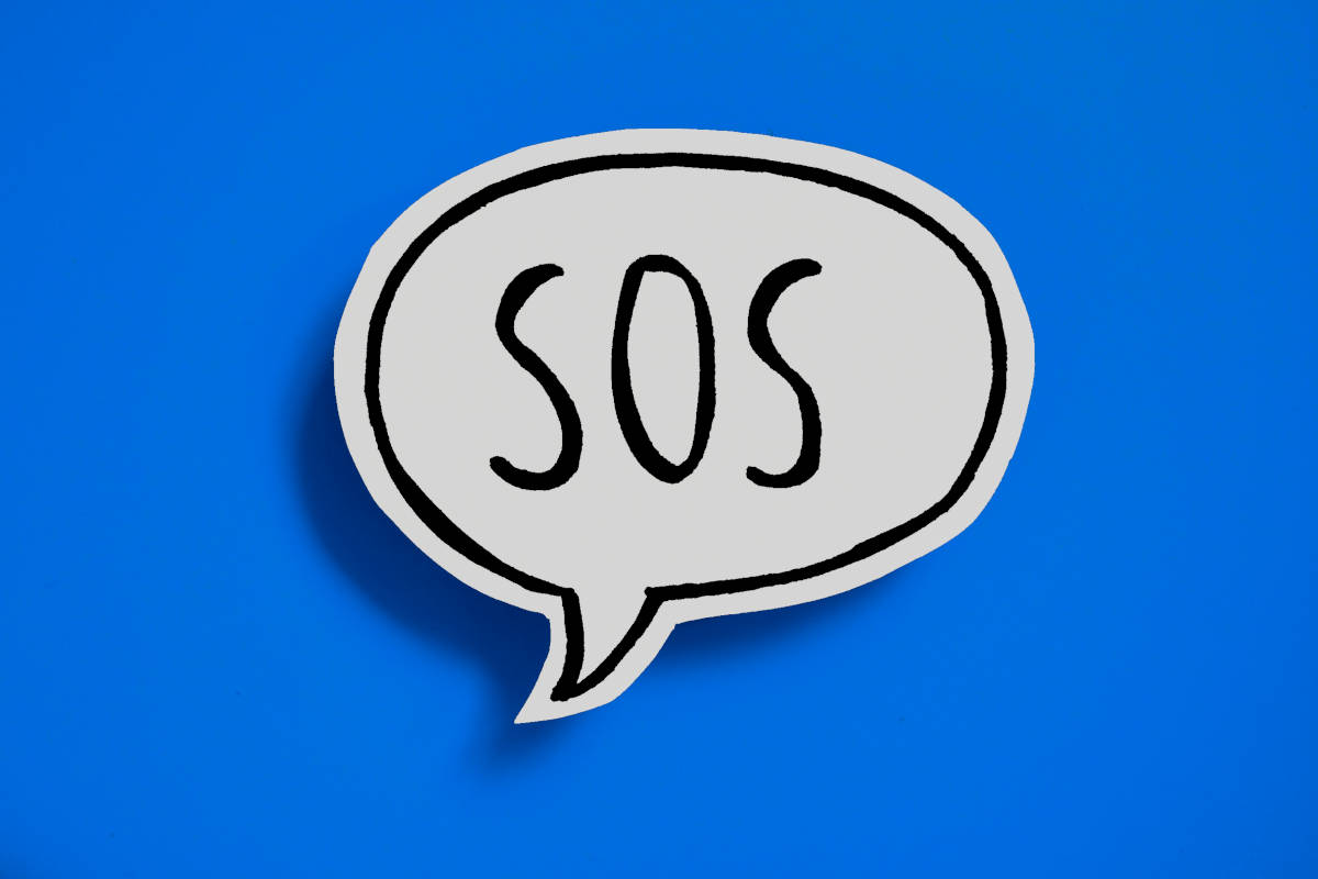 Eine weiße Sprechblase mit schwarzem SOS als Text auf blauem Hintergrund