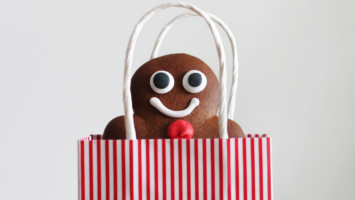 Bild einer rot-weiß gestreiften Papiertüte, aus der eine Lebkuchenfigur herausguckt.