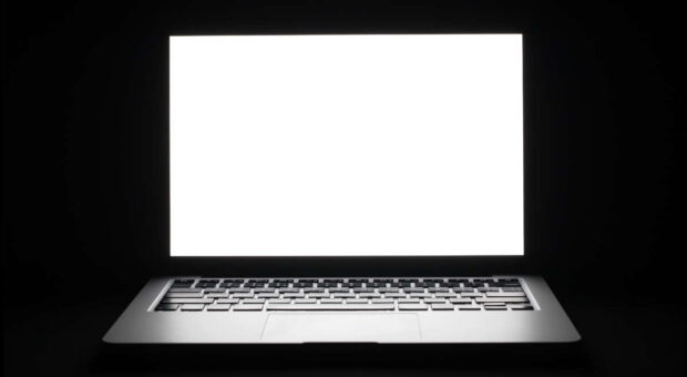 Laptop mit weißem Bildschirm vor schwarzem Hintergrund