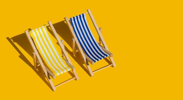 Zwei Liegestühle in der Sonne.