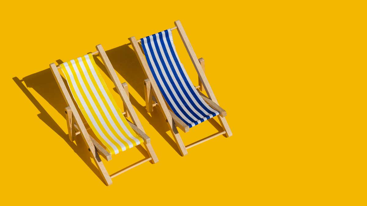 Zwei Liegestühle in der Sonne.