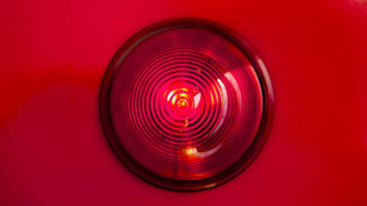 Das Bild einer roten Warnlampe auf rotem Hintergrund.