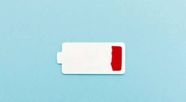 Grafik einer weißen Batterie mit rot markiertem, kritischen Ladezustand vor hellblauem Hintergrund