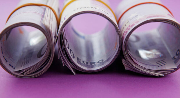 3 Rollen 500-Euro-Scheine auf lila Hintergrund