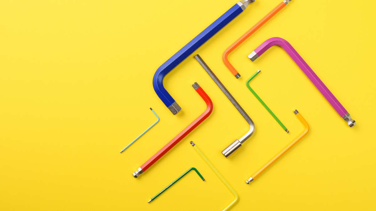 Grafik aus ineinander verschränkten bunten Imbusschlüsseln vor gelbem Hintergrund