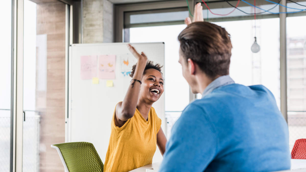 2 Personen im Büro, die sich einen High-Five geben.