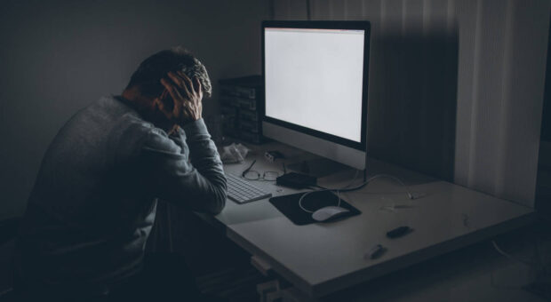 Mann vor Computer in der Nacht