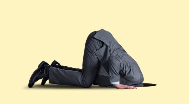 Mann im Anzug, Kopf in einem Loch im Boden