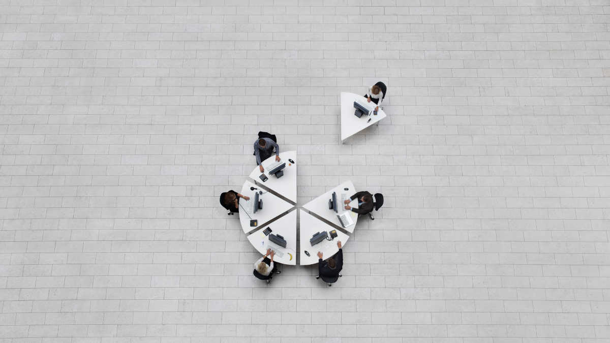 Menschen an Tischen von oben, eine Person sitzt abseits