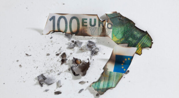 Verbrannter 100-Euro-Schein auf weißem Untergrund.