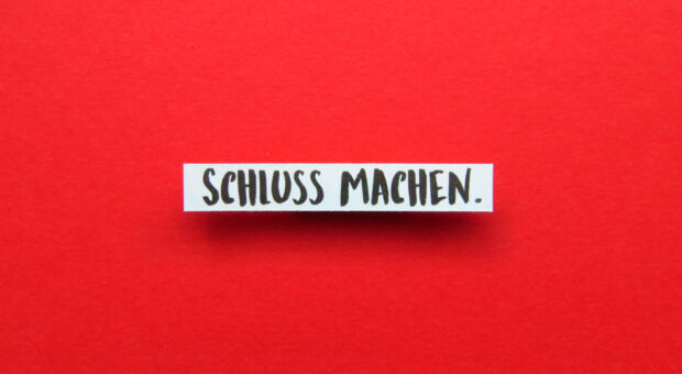 Schriftzug "Schluss machen." auf rotem Hintergrund.