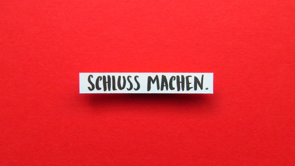 Schriftzug "Schluss machen." auf rotem Hintergrund.