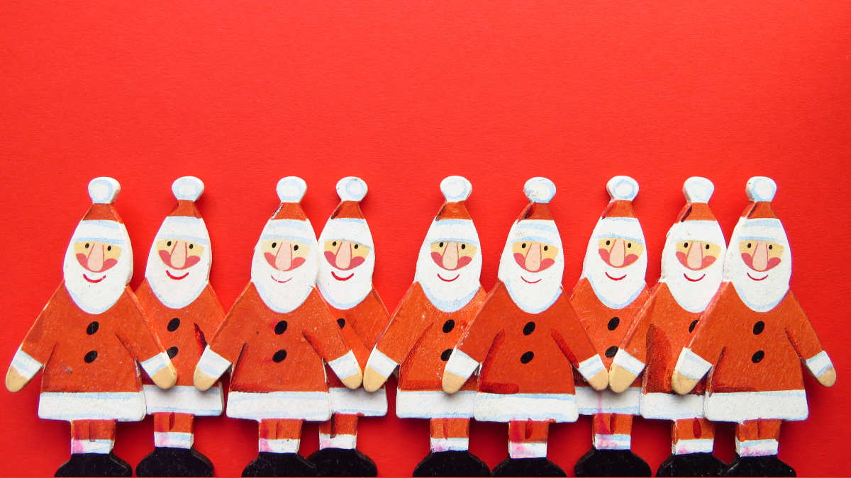 Bild mehrerer hölzerner Weihnachtsmannfiguren auf rotem Hintergrund.