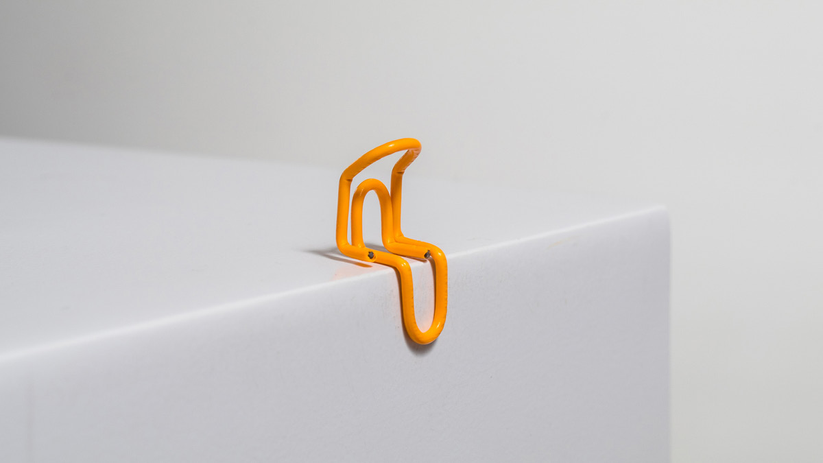 Gebogene Büroklammer, die symbolisch einen traurigen Menschen darstellen soll