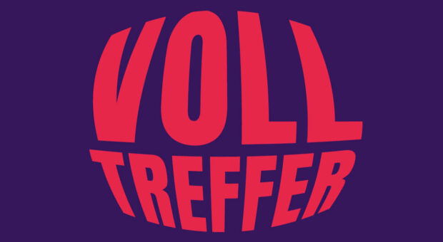 Auf lila Hintergrund steht groß in rot das Wort "Volltreffer"