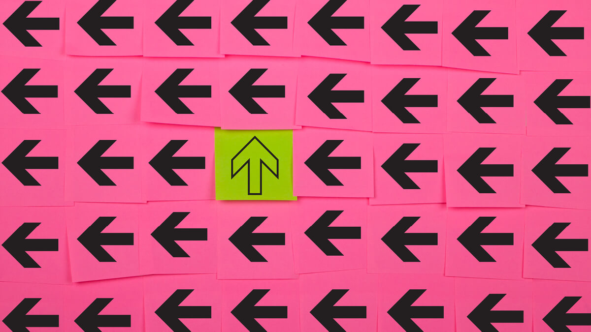 Viele schwarze Pfeile auf pinkem Hintergrund, die nach links zeigen mit einem gelben Pfeil auf gelbem Hintergrund in der Mitte, der nach oben zeigt.