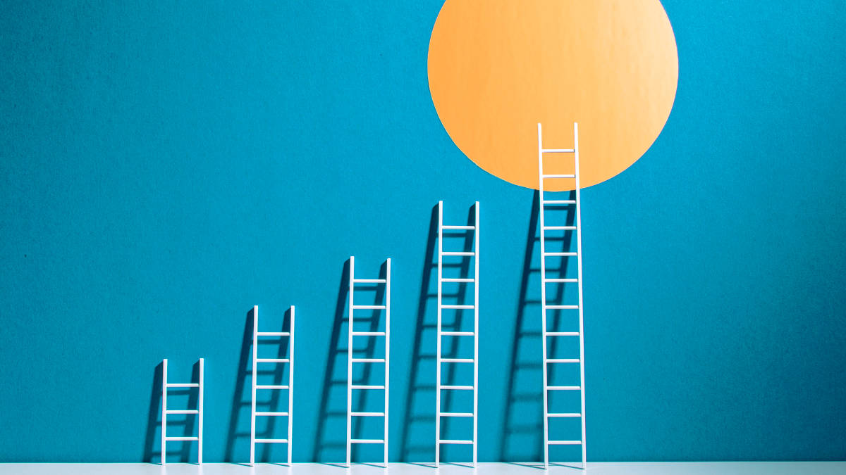 Das Bild hat einen blauen Hintergrund auf dem auch ein gelber Kreis zusehen ist. Davor sind 5 weiße Leitern, die Schritt für Schritt größer werden und die Letzte erreicht den gelben Kreis.