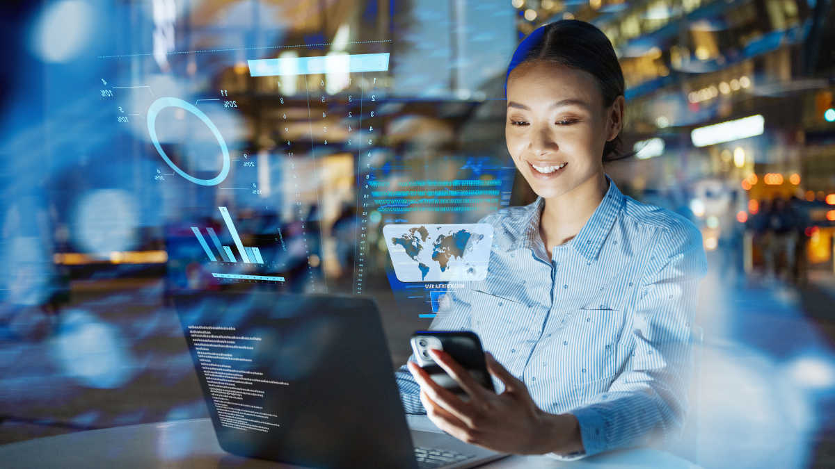 Bild einer Frau, die an einem Laptop arbeitet. Darüber schweben Daten-Visualisierungen, die Künstliche Intelligenz symbolisieren sollen.