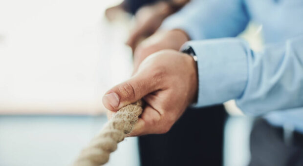 Mehrere Personen ziehen an einem Tau.