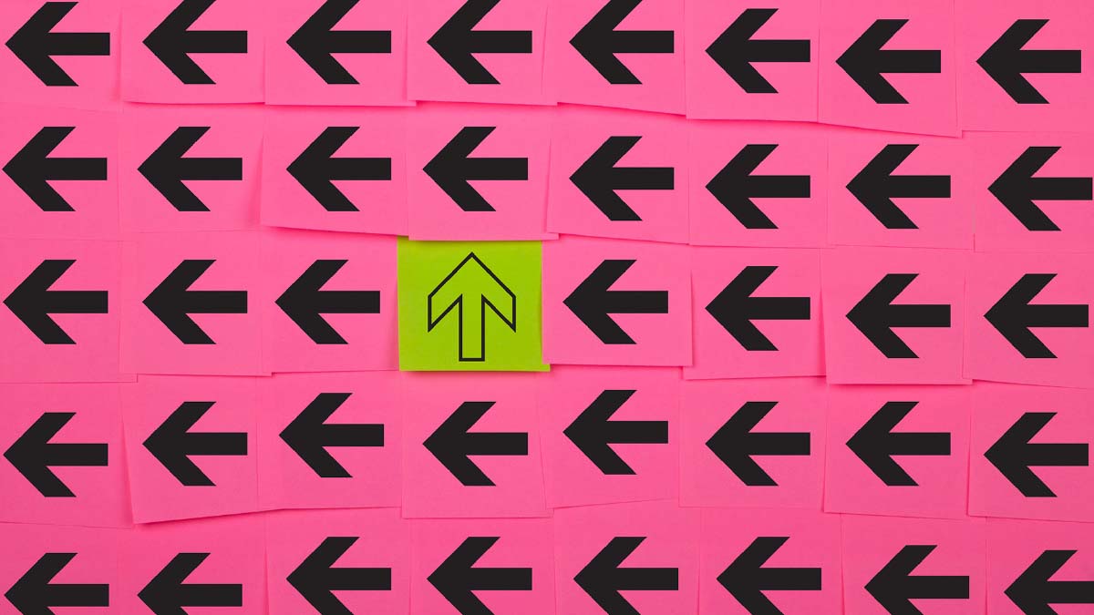 Viele schwarze Pfeile auf pinkem Hintergrund, die nach Links zeigen und in der Mitte ein gelber Pfeil, der nach oben zeigt