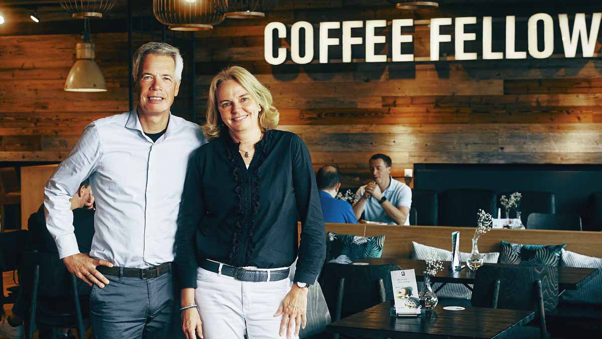 Das Gründerpaar hinter Coffee Fellows, Kathrin und Stefan Tewes, stehen vor einer Filiale ihrer Kaffeehauskette.