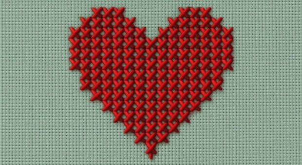 Rotes gesticktes Herz auf grün-grauem Hintergrund