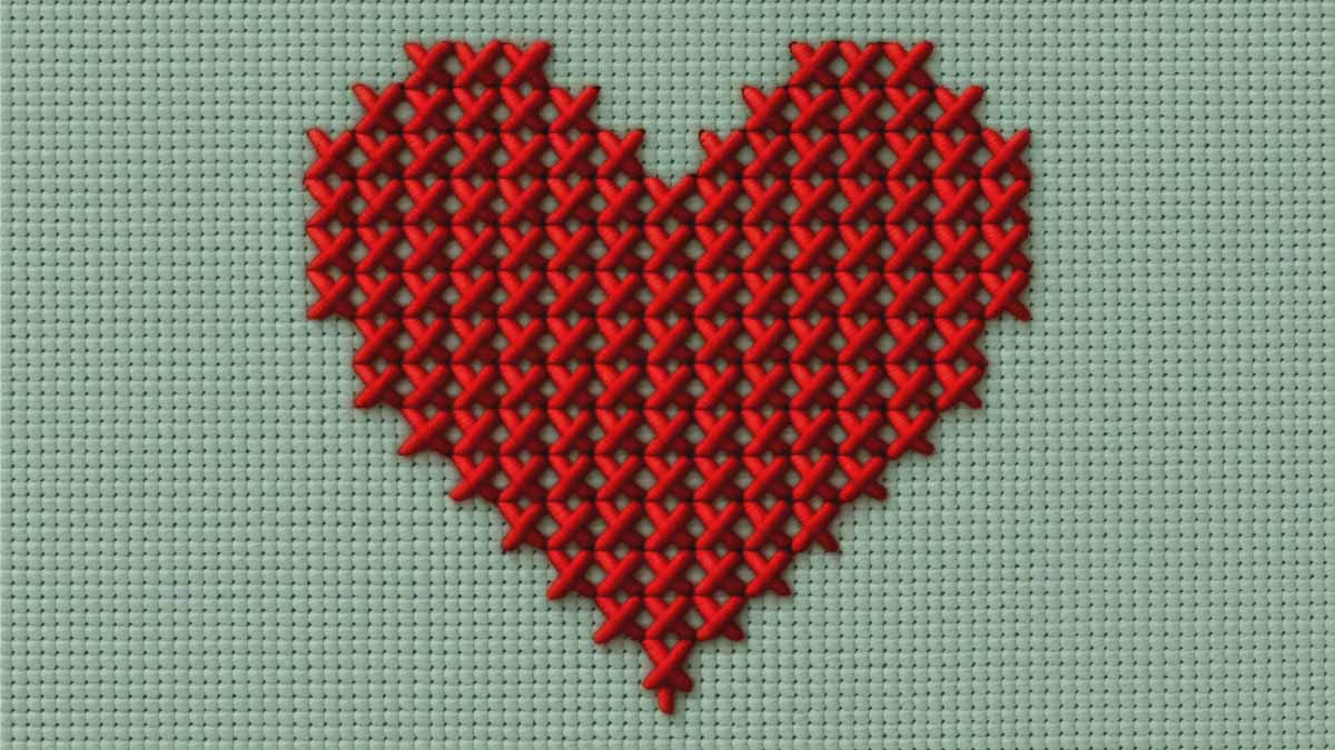 Rotes gesticktes Herz auf grün-grauem Hintergrund