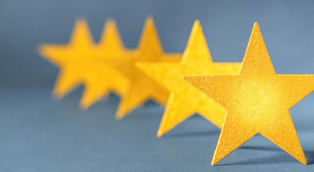 5 hintereinander stehende goldene Sterne vor blauem Hintergrund