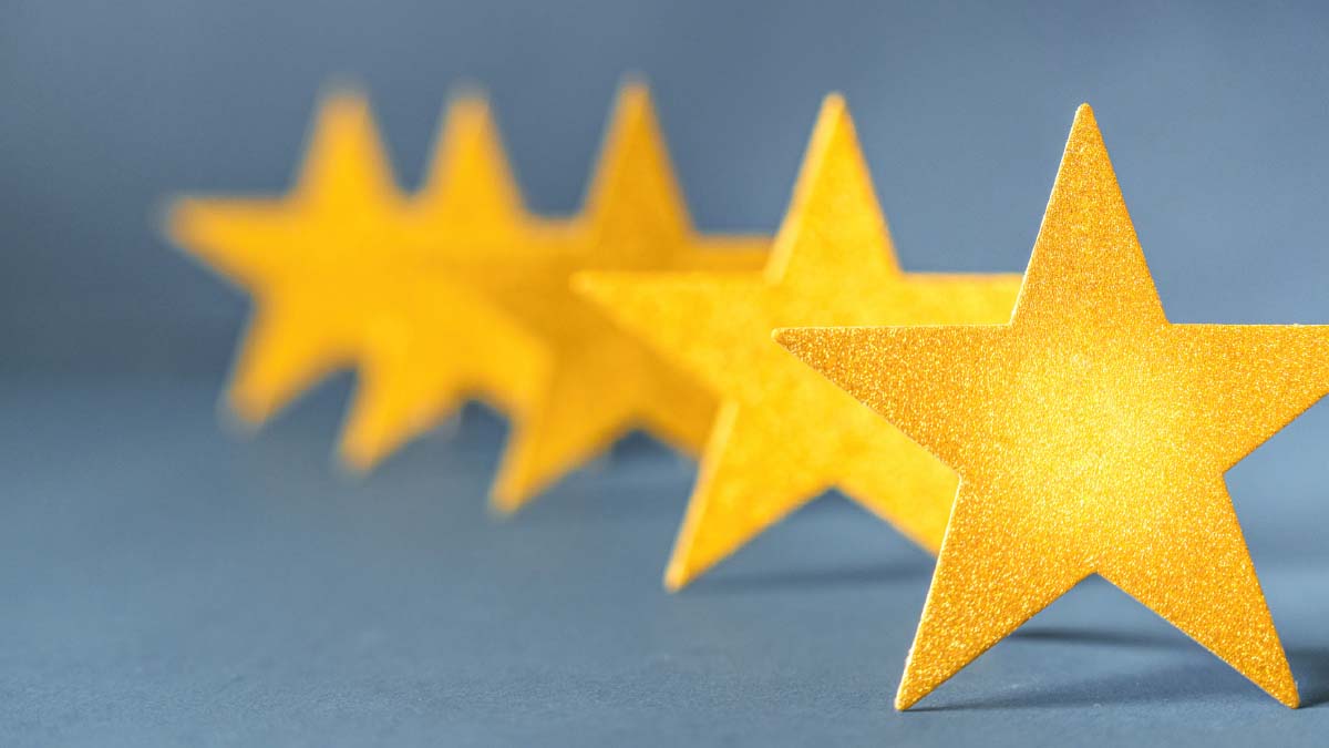 5 hintereinander stehende goldene Sterne vor blauem Hintergrund