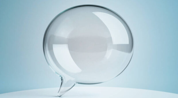 Gläserne Sprechblase vor hellblauem Hintergrund