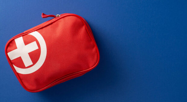 Rotes Erste-Hilfe-Set auf blauem Untergrund.