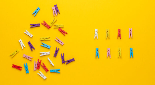 Bunde Wäscheklammern auf gelbem Hintergrund. Links unsortiert, rechts sortiert.